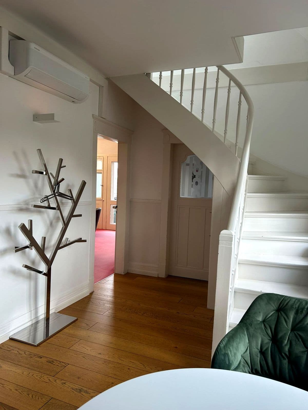 Flur der Kanzlei mit weißer Wendeltreppe und Garderobe